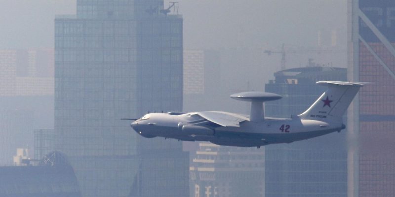 Самолет-радар А-50 в воздухе на фоне высотных домов