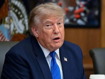 Дональд Трамп на заседании кабинета министров США в Кэмп-Дэвиде 31 июля: он одет в темно-синий костюм, галстук светло-голубого цвета с черными горизонтальными полосками, белую рубашку, а на пиджаке у него прикреплен значок с изображением флага США