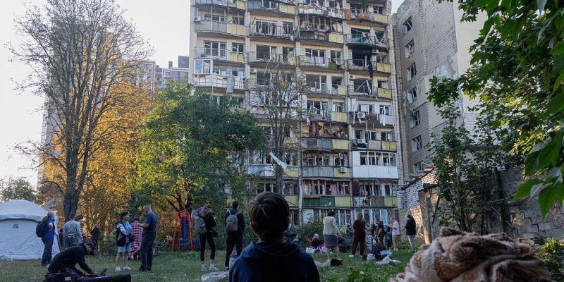 Ребенок сидит во дворе дома, по которому пришелся удар.