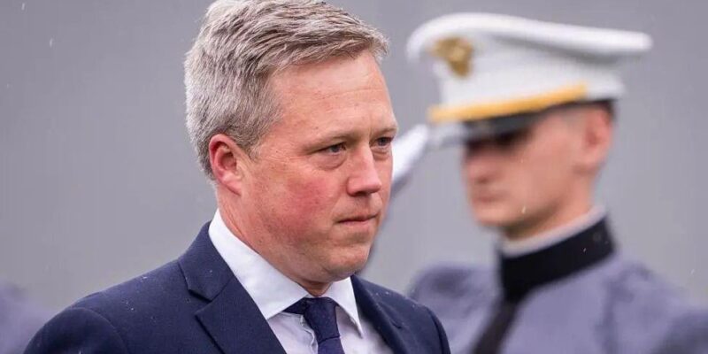 Министр армии Дэн Дрисколл прибывает на церемонию вручения дипломов в Военной академии США в Вест-Пойнте, штат Нью-Йорк; за его спиной военнослужащий отдает честь.