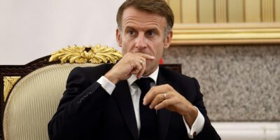 Задумчивый Макрон держит руку у рта
