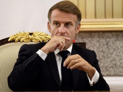 Задумчивый Макрон держит руку у рта