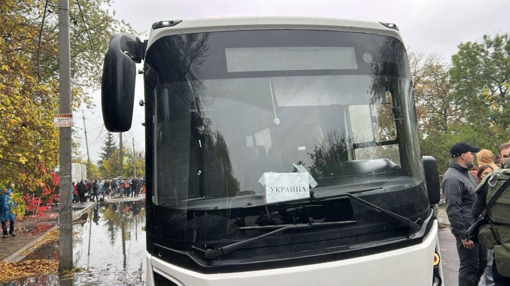 В Алешках началась эвакуация мирных жителей 1 Автобус с надписью УКРАИНА, рядом стоят люди.